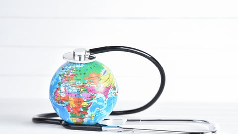 Static image of small colourful world globe encircled by a stethescope