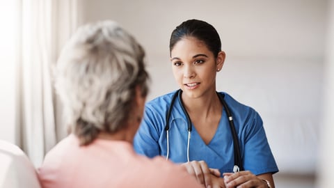 Young woman physician speaking with an older woman patient