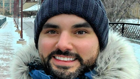 Dr. Brent Young in tuque and parka, urban winter scene in background