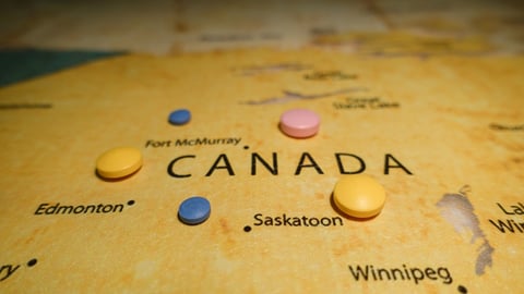 pink-blue-and-yellow-pills-on-yellow-map-of-canada