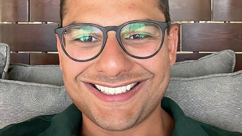 male pharmacist Samier Kamar wearing glasses and a green polo shirt