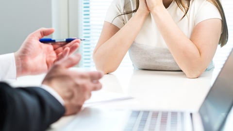 two people sitting at desk, just hands and upper body showing, hands suggest difficult conversation