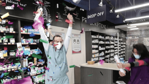 Workers celebrating in a pharmacy 