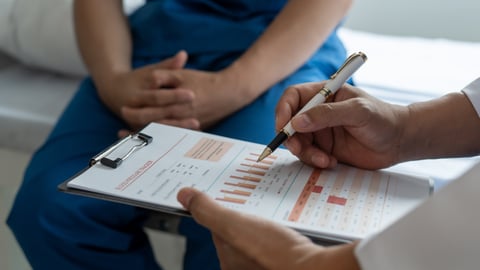 Doctor holding chart counselling man on prostate cancer testing or other medical test or health issue.