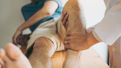 physiotherapist testing a man’s leg muscle strength