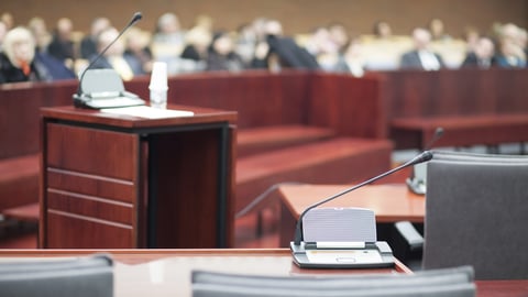 A witness stand and microphone waiting for someone to provide testimony