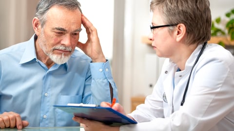 white older man looking puzzled, looking at clipboard held by female white doctor, like is being tested for memory or dementia.