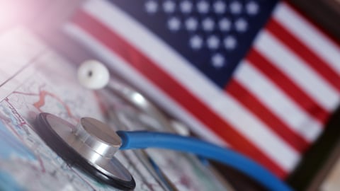 A stethoscope is seen with a U.S. flag in the backdrop.