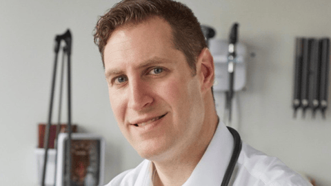 Dr. Eric Cadesky smiling for a photo in an exam room