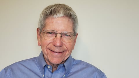 Older man with glasses in a blue shirt