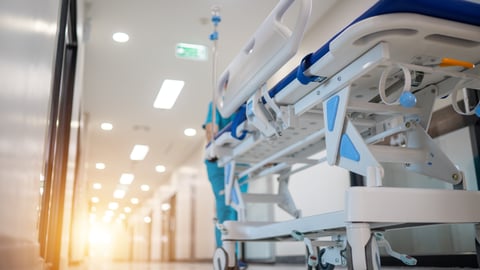 Hospital worker pushing a gurney 