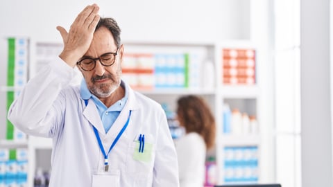 white mail pharmacist holding hand to head