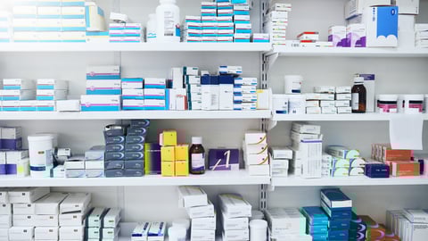 Shelf in a pharmacy full of boxes and bottles of drugs