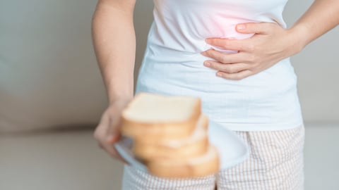 woman, torso showing, holding plate of bread and holding gut