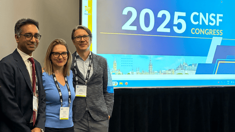 Three physicians, a man, a woman and a man, all in office attire stand in front of a screen saying 2025 CNSF congress