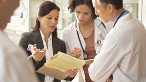 Physicians discussing a patient's paperwork