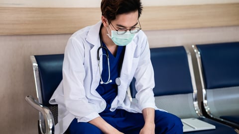 Young resident physician sitting tired in a waiting room