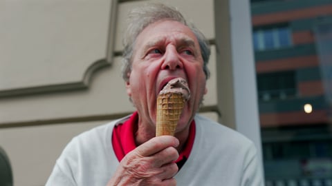 Older man eating a chocolate ice cream cone