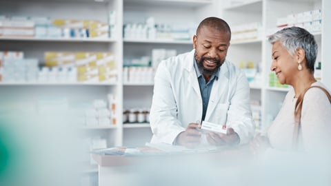 A black pharmacist talking to a black senior woman abut medication
