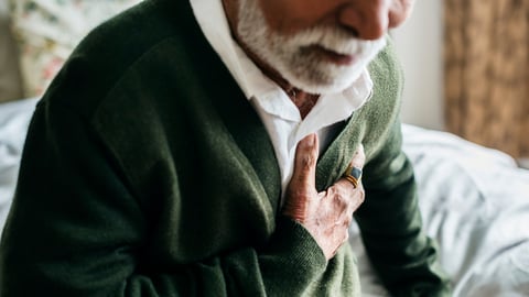 Older man holding his heart in pain