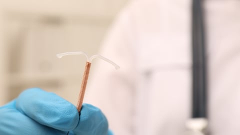 A doctor holding an IUD.