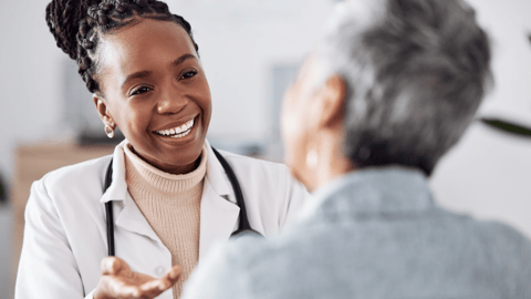 Smiling doctor talks to a patient in an office.