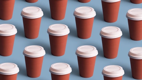Multiple take out coffee cups against a blue background