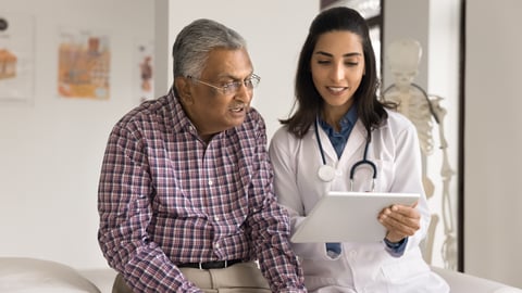 Young doctors showing a tablet screen to an older patient