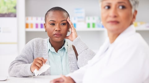 Customer looking irritated with a harried pharmacist