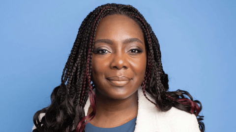 Dr. Zainab Abdurrahman smiling for a photo in a white lab coat