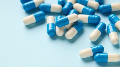 A pile of blue and white capsule pills