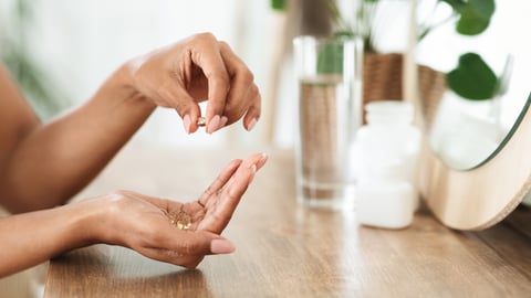 hands taking gel vitamins