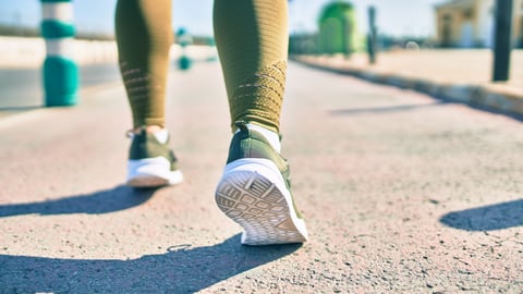 Close up of a woman's sneakers as she walks backwards