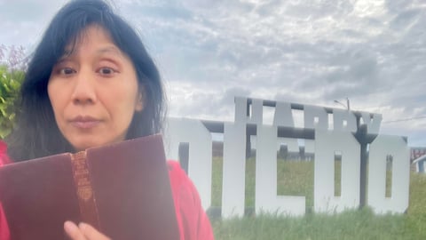 Dr. Melissa Yuan-Innes in front of a sign on Dildo, NL