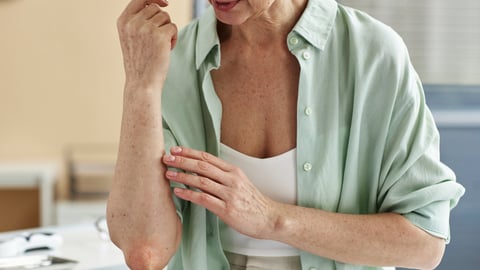 Older woman feeling her elbow because she is experiencing joint pain