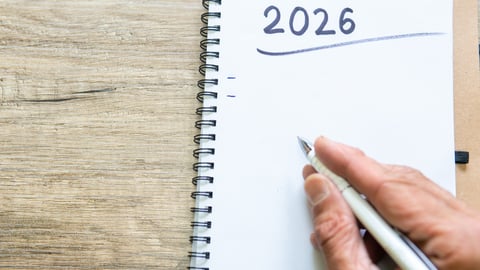A notebook with 2026 at the top and a pencil and hand ready to write a list