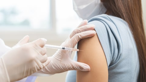 Young woman receiving a vaccination in her left shoulder