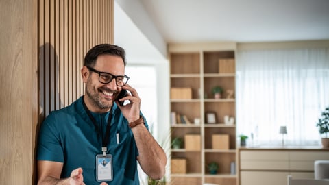 Young male physician chatting on the phone with a patient