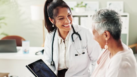 Woman doctor smiling and laughing with an older patient