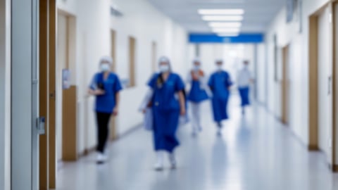 Blurry view of workers in a hospital hallway