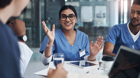 Doctors sitting around at a table in an education setting.