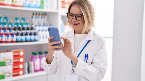 A pharmacist holding a smartphone