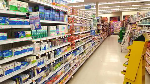 Over-the-counter drugs and vitamins are seen on a pharmacy shelf.