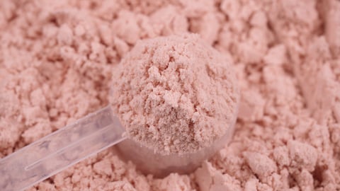 Pile of pink protein powder supplement