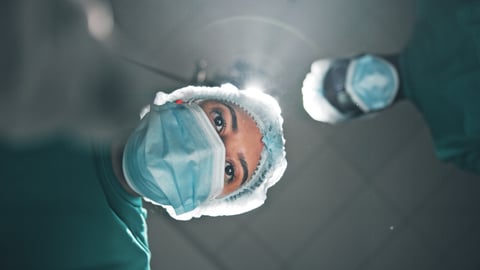Surgeon looking down over a patient