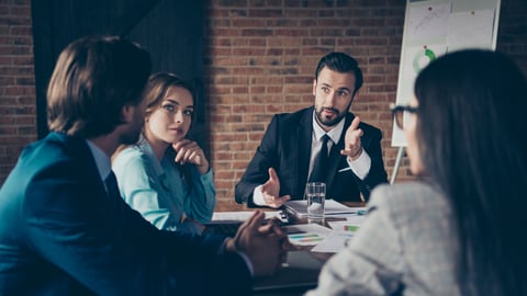 People in business clothes around a board table