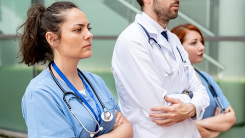 A group of healthcare workers in a row looking serious