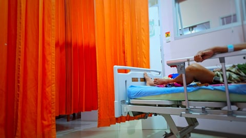 Orange curtains separating a patient in a hospital bed