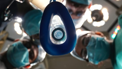 View of anesthesia mask held by medical team in operation theatre.