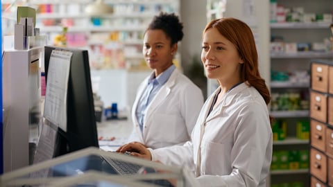 Two younger women pharmacists working behind the counter